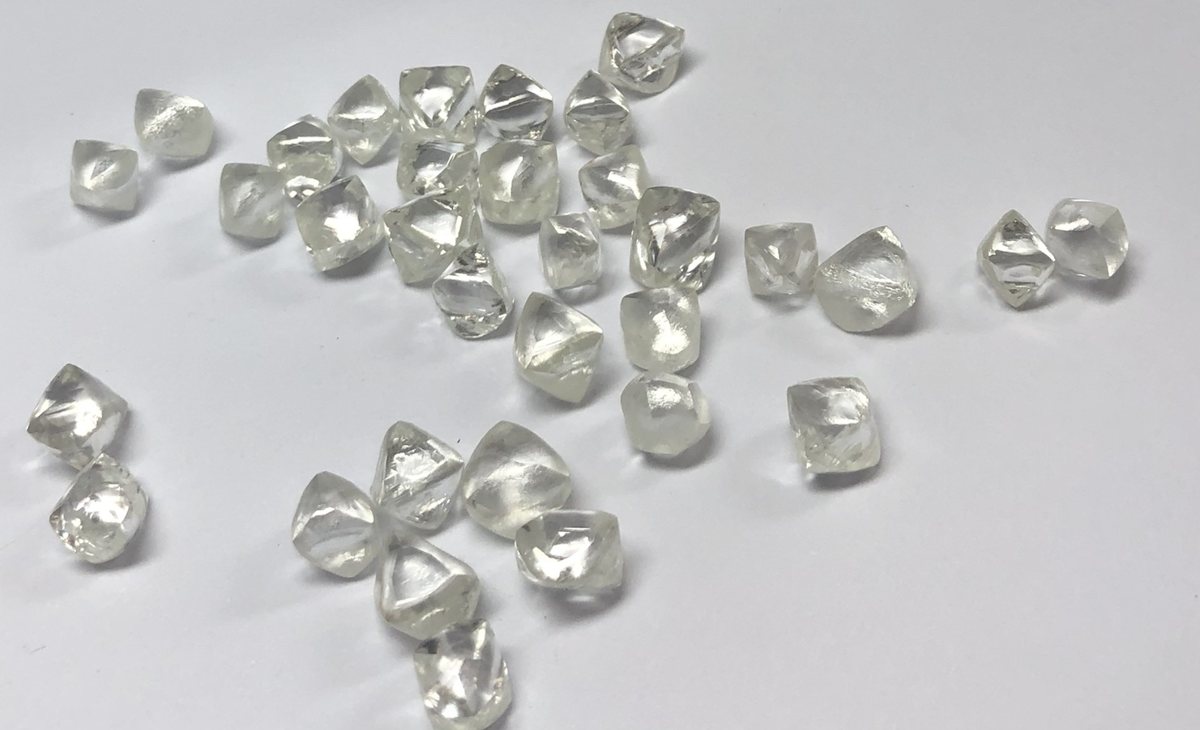 Octahedral rough diamonds spread on a white table