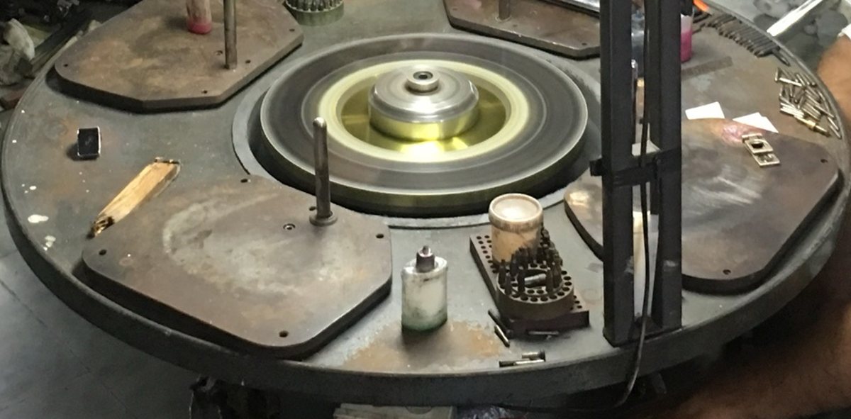 A round polishing table with a diamond-coated wheel at its center